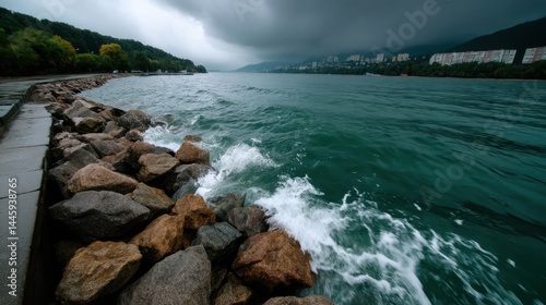 Stormy Weather Over a Lake with Rocky Shoreline and Urban Background under Dark Clouds