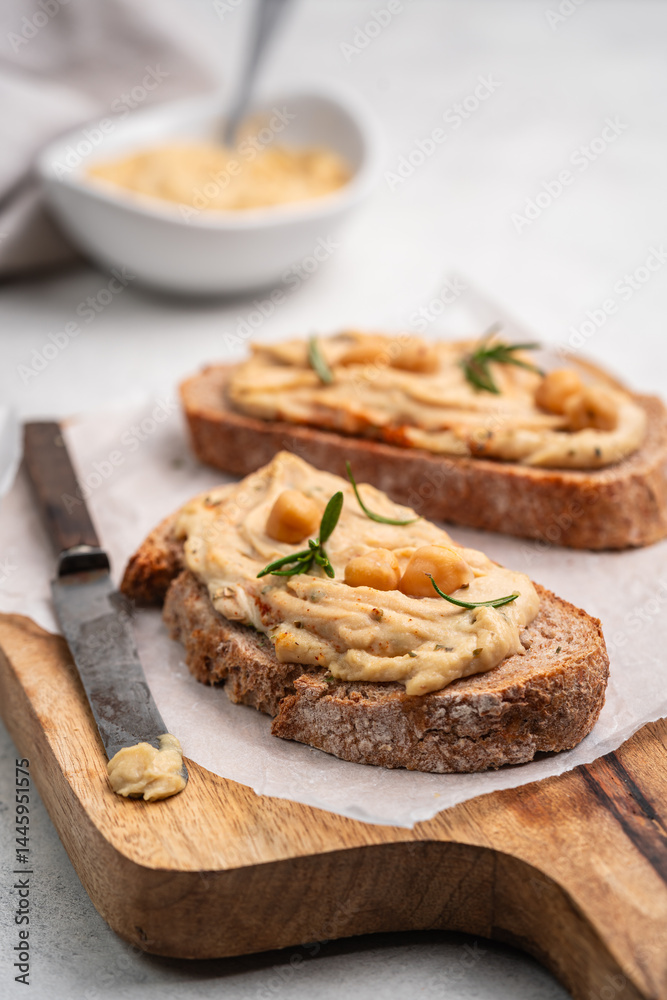 Delicious sandwiches with hummus and ingredients on white table, flat lay. High quality photo