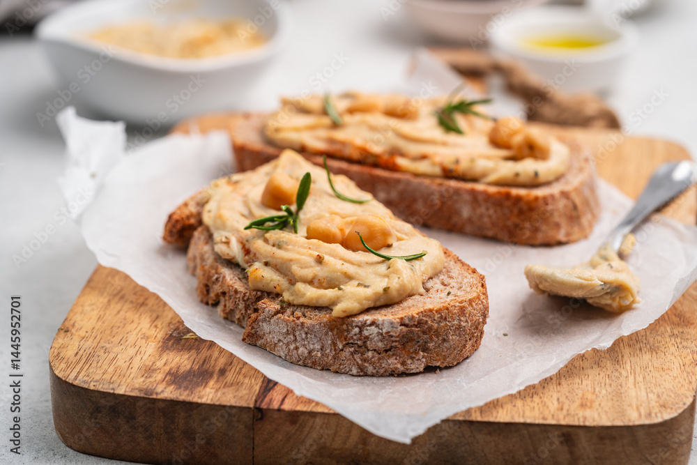 Delicious sandwiches with hummus and ingredients on white table, flat lay. High quality photo