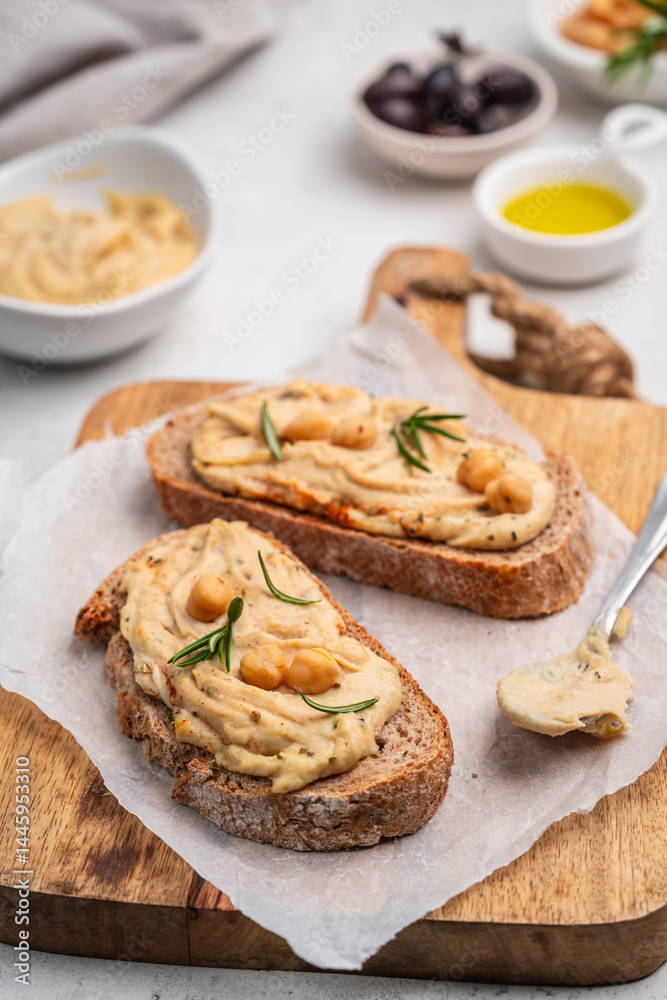 Delicious sandwiches with hummus and ingredients on white table, flat lay. High quality photo