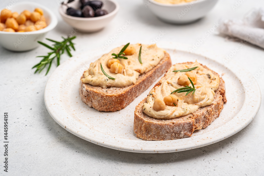 Delicious sandwiches with hummus and ingredients on white table, flat lay. High quality photo