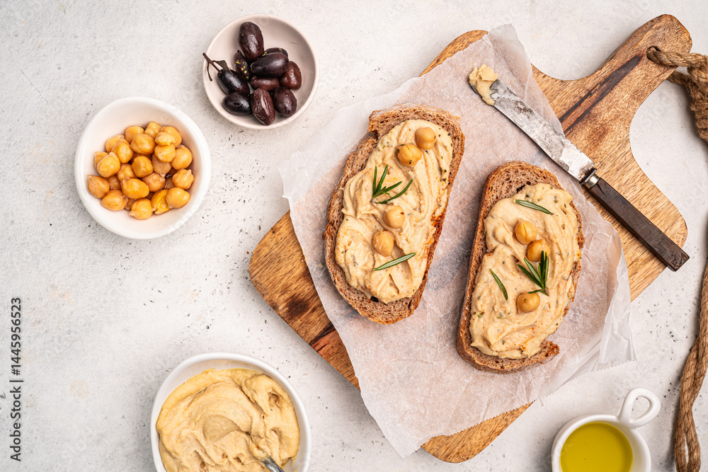 Delicious sandwiches with hummus and ingredients on white table, top view, flat lay. High quality photo
