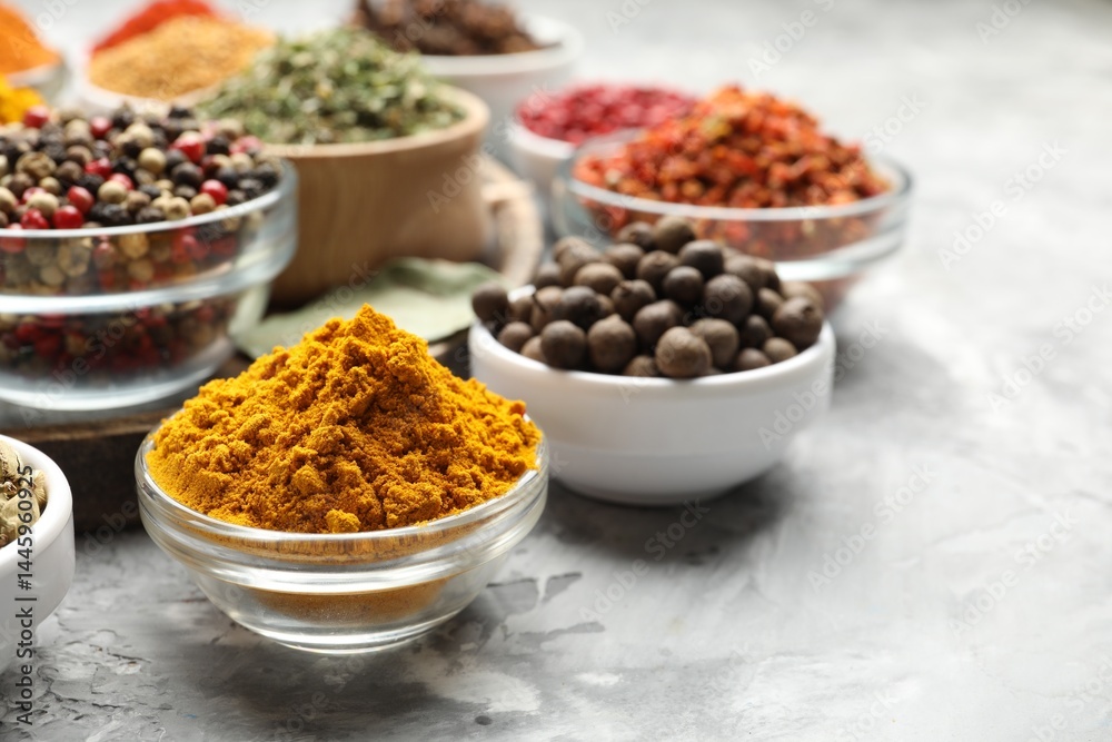 Different aromatic spices on grey table, closeup. Space for text Different aromatic spices on grey table, closeup. Space for text