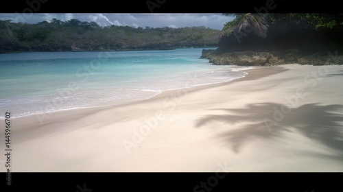 Pristine tropical beach, soft waves, palm tree shadows on white sand.  Tranquil, secluded paradise.  Perfect for relaxation and travel.