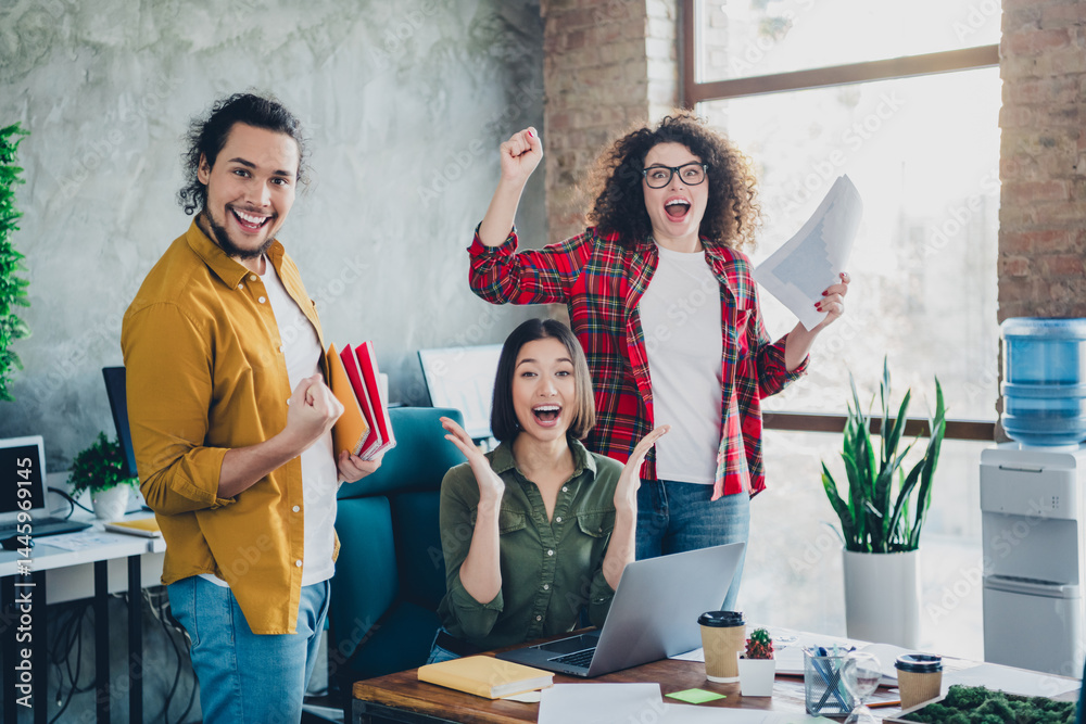 Fototapeta premium Diverse coworkers celebrating success together in a modern workspace with cheerful expressions and energy