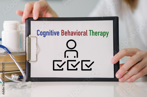 A clipboard with a person on it and the words cognitive behavioral therapy written below.