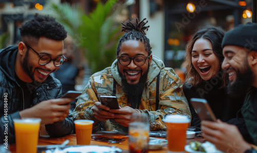 Friends enjoying drinks and laughter while using smartphones at a lively outdoor café.
