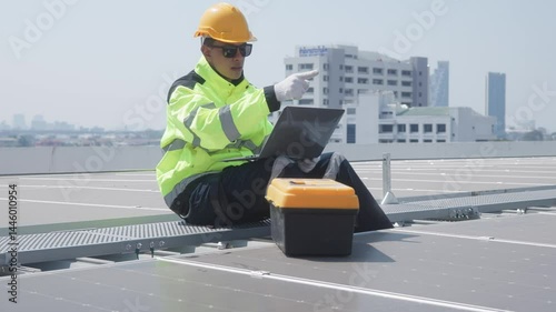 Engineer inspecting solar panels using laptop on rooftop