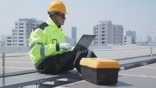 Engineer inspecting solar panels using laptop on rooftop