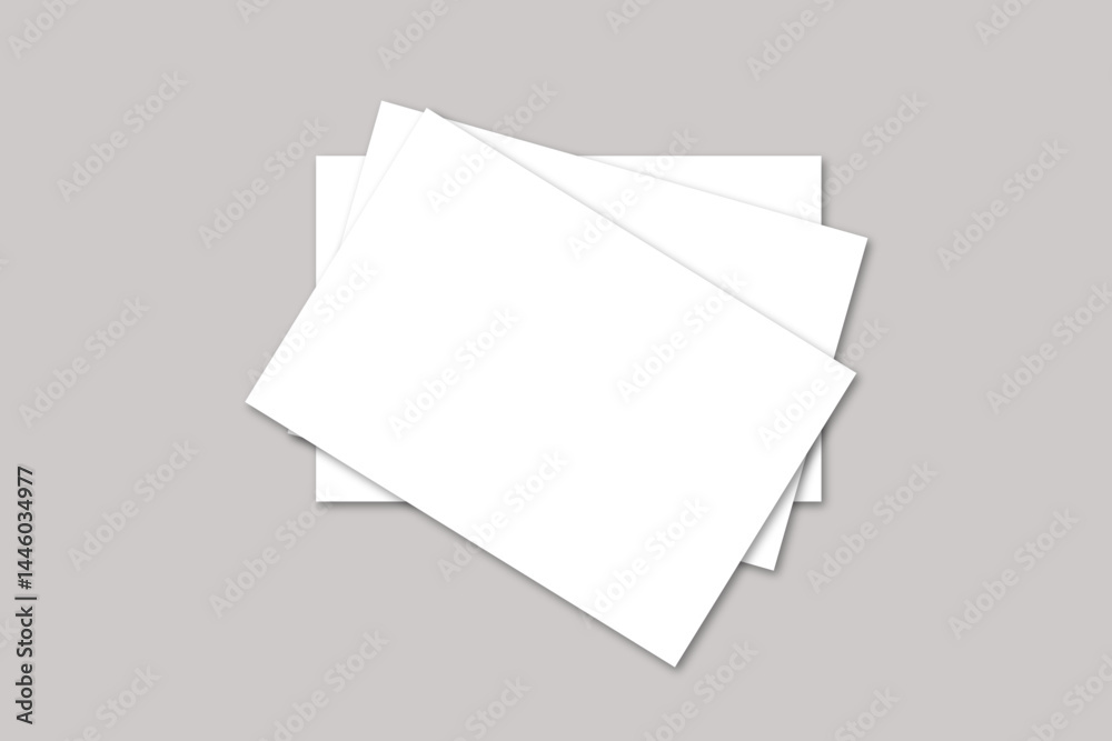 A top view of three white rectangular sheets of paper stacked on a gray surface in a studio shot A top view of three white rectangular sheets of paper stacked on a gray surface in a studio shot