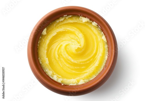 Ghee in a bowl, clarified butter with a swirl pattern on a white background
