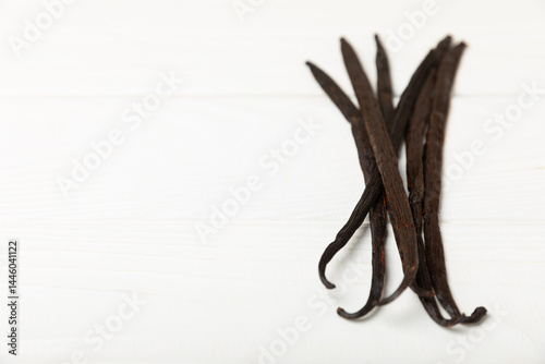 Fototapeta Naklejka Na Ścianę i Meble -  Vanilla pods on a textured background. Vanilla flowers and seeds. vanilla stick bean. Aromatic spicy spice for pastries and desserts. Seasoning. Space for text. Copy Space