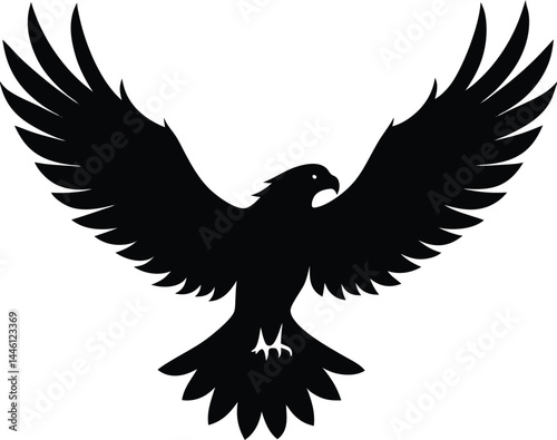 silhouette of a hawk with wings open landing 