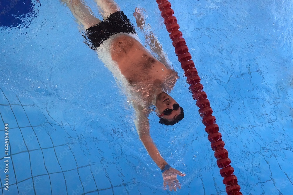 Man swimming in a pool back stroke