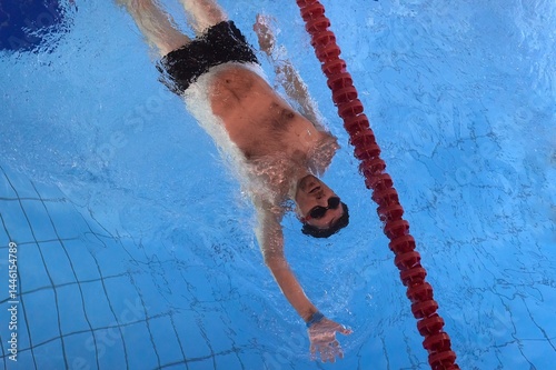 Obraz na płótnie Man swimming in a pool back stroke w salonie