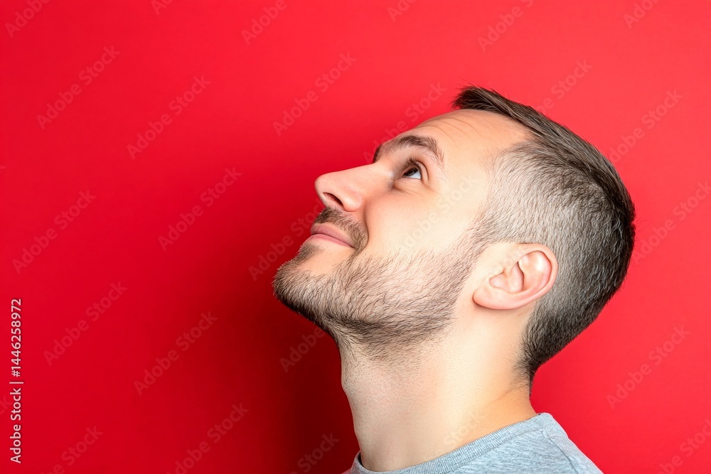 Obraz premium Classy men's short caesar haircut - midlife white man with hair. Red solid background. A man with a stylish hairdo looking confident. Conceptual art of style for aging men.