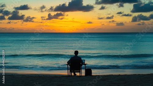 Obraz na płótnie Man works on laptop at beach during beautiful sunset w salonie