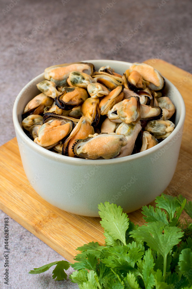 Cleaned boiled mussels in a bowl on a dark background Cleaned boiled mussels in a bowl on a dark background
