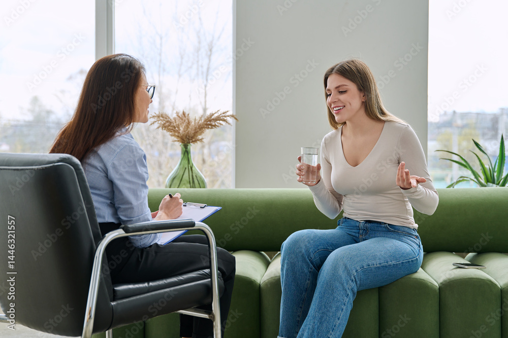 Young woman in mental session talking to female psychologist, therapist