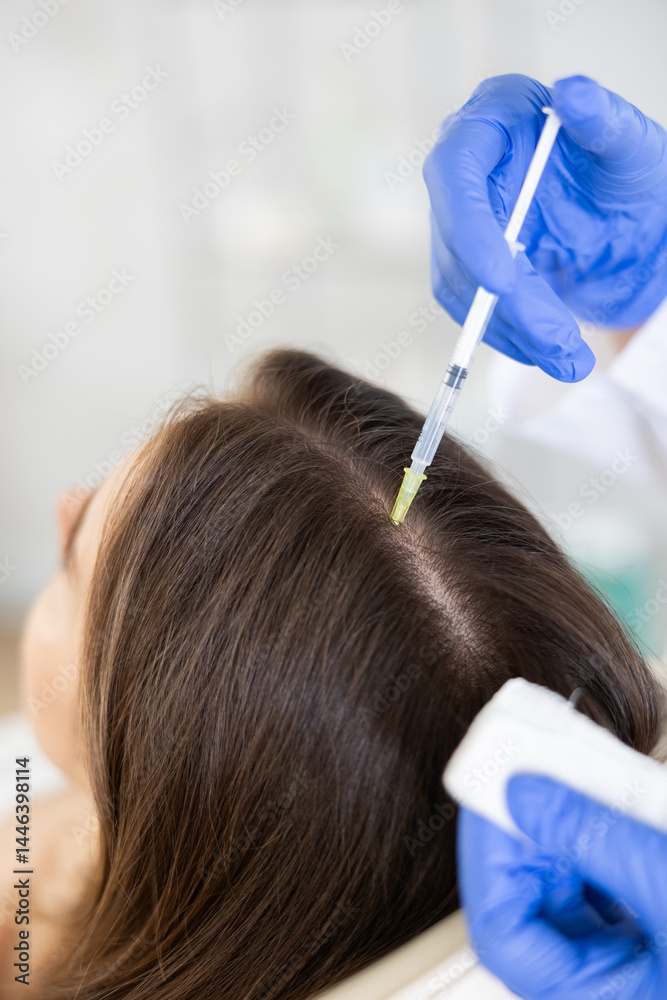 Naklejka premium Young female patient lying on clinical chair undergoing hair care procedure by injection method
