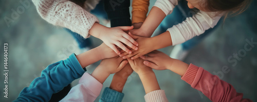 Group of children standing indoors and putting their hands together. Unity and teamwork concepts.