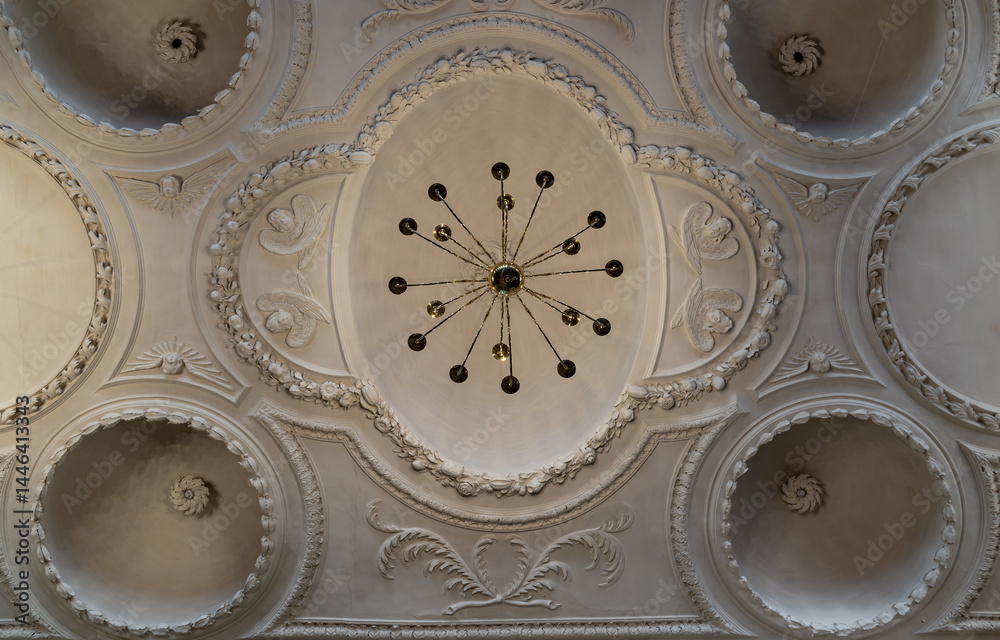 Look up at A stunning chandelier hanging on The ceilings are made of plaster is carved into a dome shape interior of The Church of King Charles the Martyr. use it as your Wallpaper, Poster and Space.