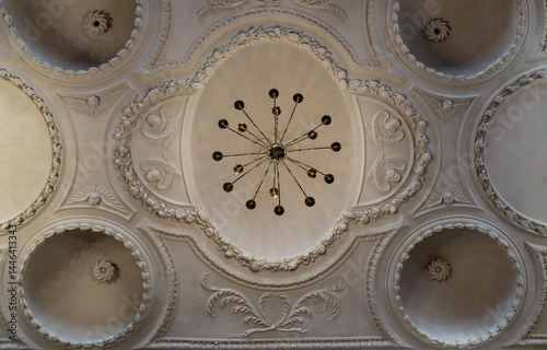 Obraz na płótnie Look up at A stunning chandelier hanging on The ceilings are made of plaster is carved into a dome shape interior of The Church of King Charles the Martyr. use it as your Wallpaper, Poster and Space. w salonie