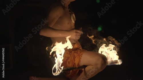 Polynesian poi fire dancer spinning flaming torches at night, creating vivid light trails against a dark sky. Perfect for themes of tradition, performance, or dramatic visual storytelling.
