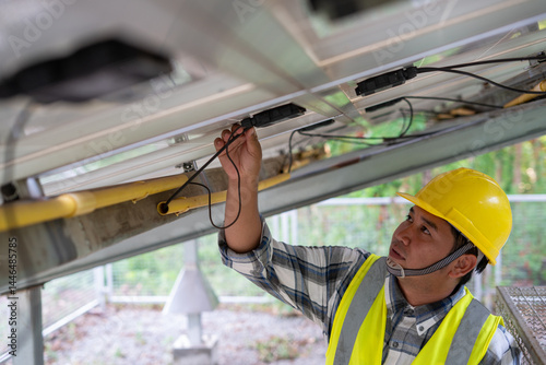 Obraz na płótnie Solar Panel Technician: A focused technician meticulously inspects the wiring of a solar panel, showcasing expertise and attention to detail in renewable energy maintenance. w salonie
