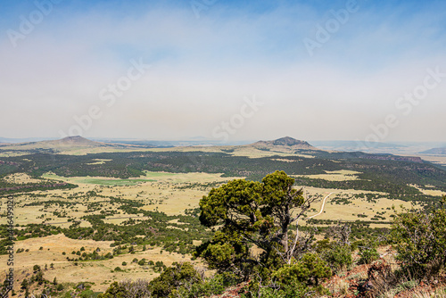 Serene landscape of the volcanic field seen from Crater Rim Trail at Capulin Volcano National Monument. Smoke in background is from wildfires at the time.