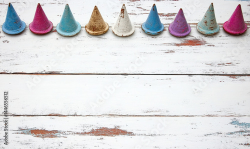 Colorful party hats arranged in a row on a rustic wooden surface creating a festive and cheerful atmosphere for celebration or event decoration