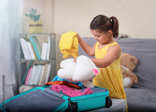 A child collects things in suitcase to go on vacation