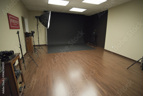 Interior studio photography space backdrop makes you feel calm and focused. Photographer using professional equipment for photo shoot in room with wooden floor
