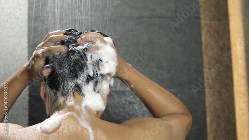 man bathing wash his hair with shampoo in shower. for hygiene. Liquid drops, and foam wash for texture and cleaning routine. photo