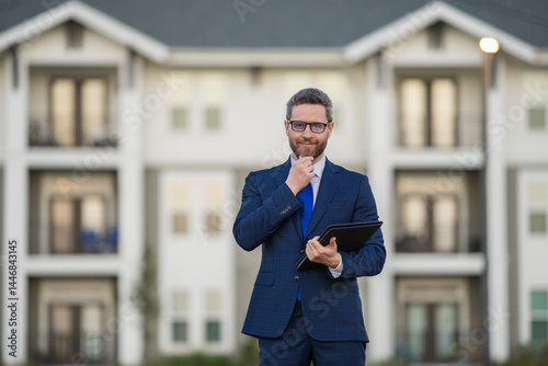 Real estate agent business man in suit hold holder clipboards outside. Hispanic Businessman. Business Man broker or real estate agent. Business man in suit outdoor. Real estate business man.