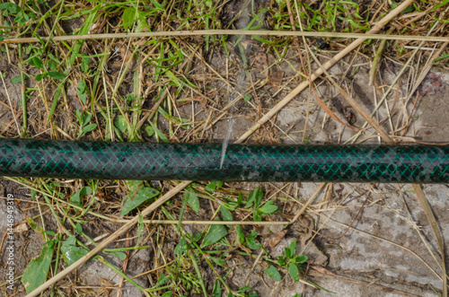 The hose is torn and water is pouring. There is a hole in the watering hose