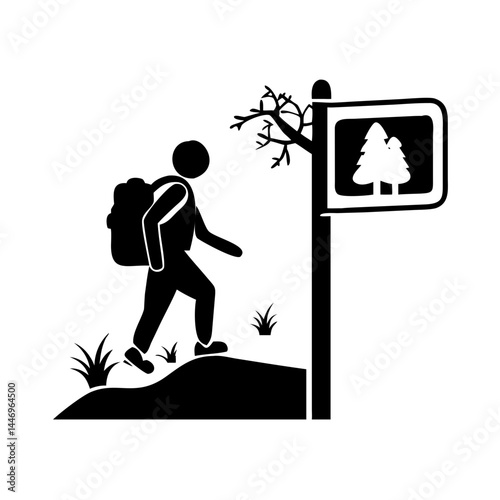 Hiker approaching a trail marker indicating a forest path