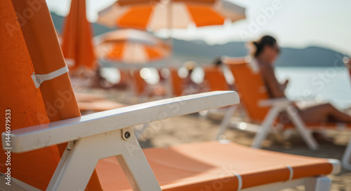 close-up of an orange beach chair with white frame on a sunny day