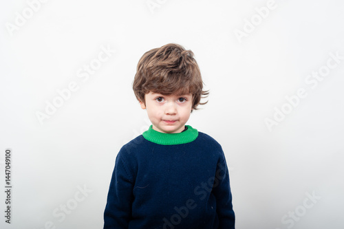 Child with brown hair wearing sweater stands still
