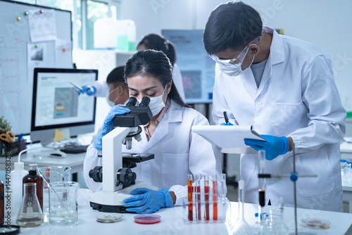 In the laboratory, researchers conduct blood tests and chemical analysis, with doctors taking notes and closely examining samples through the microscope for ongoing research.