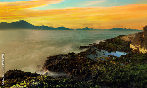 Landscape view of sky melts into warm hues of golden sunset, reflecting beautifully on the tranquil sea background. coastal creating a breathtaking view.