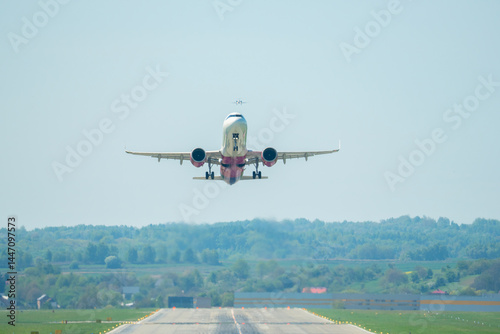 Passengers experience the thrill of takeoff as a plane ascends into the clear blue sky above lush green landscapes