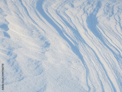 Obraz na płótnie Beautiful winter background with snowy ground. Natural snow texture. Wind sculpted patterns on snow surface. w salonie