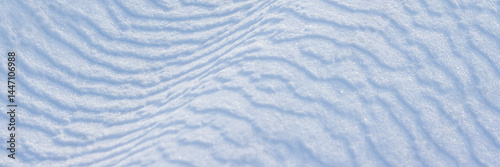 Obraz na płótnie Beautiful winter background with snowy ground. Natural snow texture. Wind sculpted patterns on snow surface. Wide panoramic texture for background and design. w salonie
