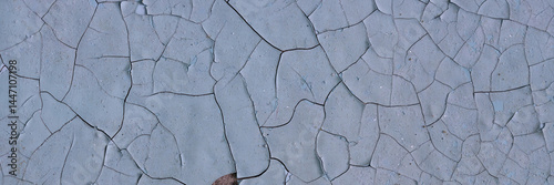 Obraz na płótnie Peeling paint on the wall. Panorama of a concrete wall with old cracked flaking paint. Weathered rough painted surface with patterns of cracks and peeling. Panoramic texture for background and design. w salonie