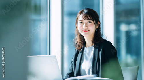 オフィスで働く自信に満ちた笑顔の女性 ノートパソコンで調べもの Generative AI