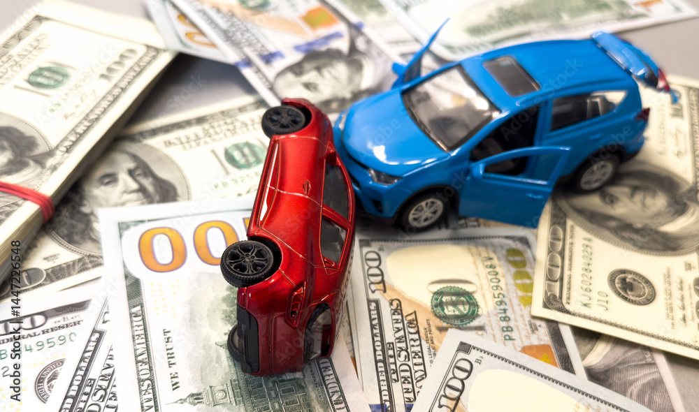 Toy cars in accident on a background of 100 dollar bills