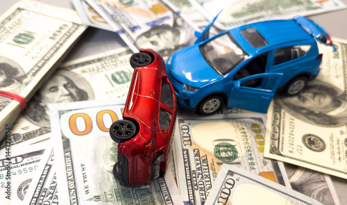 Obraz na płótnie Toy cars in accident on a background of 100 dollar bills w salonie