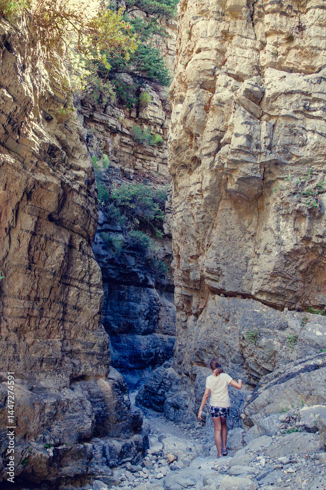 Exploring a narrow canyon with rugged rock formations and lush greenery
