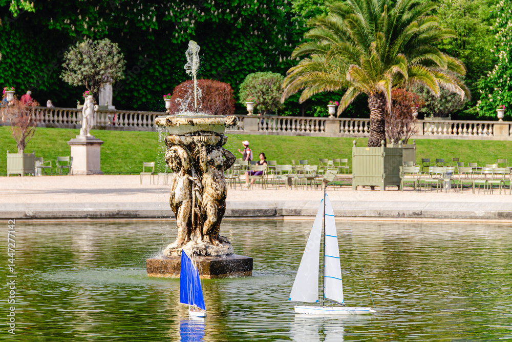 Model sailing boats glide across the pond in the Garden Luxembourg.